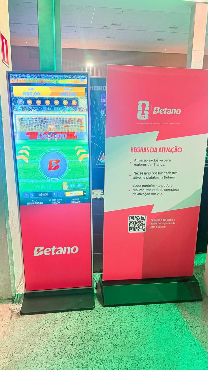 Totem interativo exibindo jogo personalizado ao lado do banner de regras da ativação